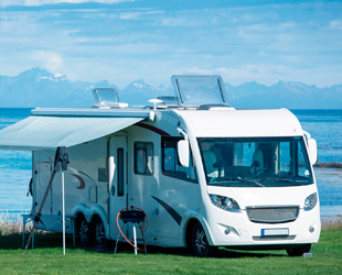 camper in sosta al lago con panorama alpino