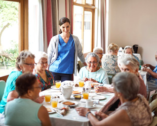 anziane al tavolo a pranzo in sala da pranzo di casa di riposo