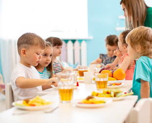 mensa d'asilo con bimbi al tavolo