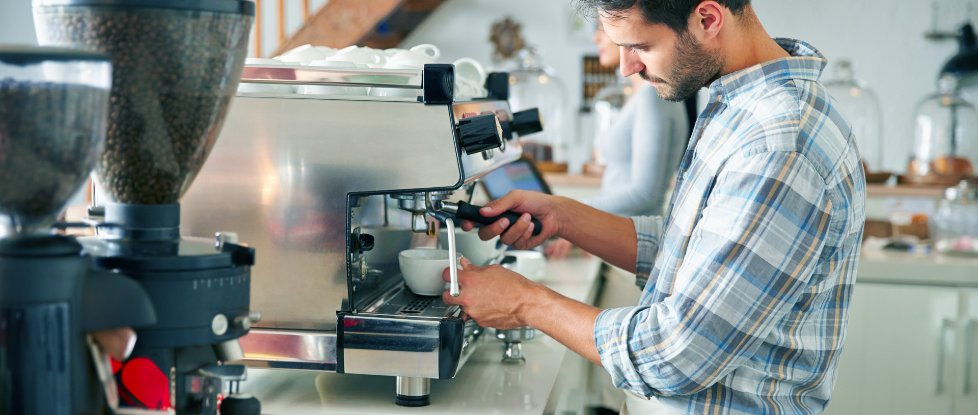 barista uomo alla macchina del caff mentre prepara un caffè