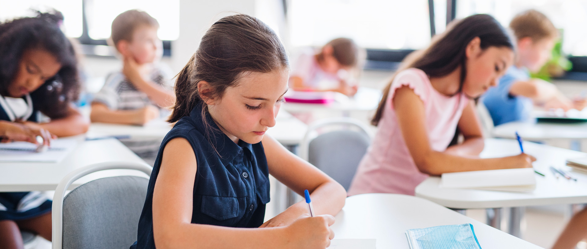 due bambine in classe mentre scrivono un tema