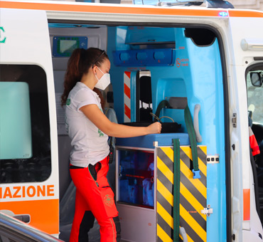 volontaria della Croce Rossa apre il portellone laterale dell'ambulanza 